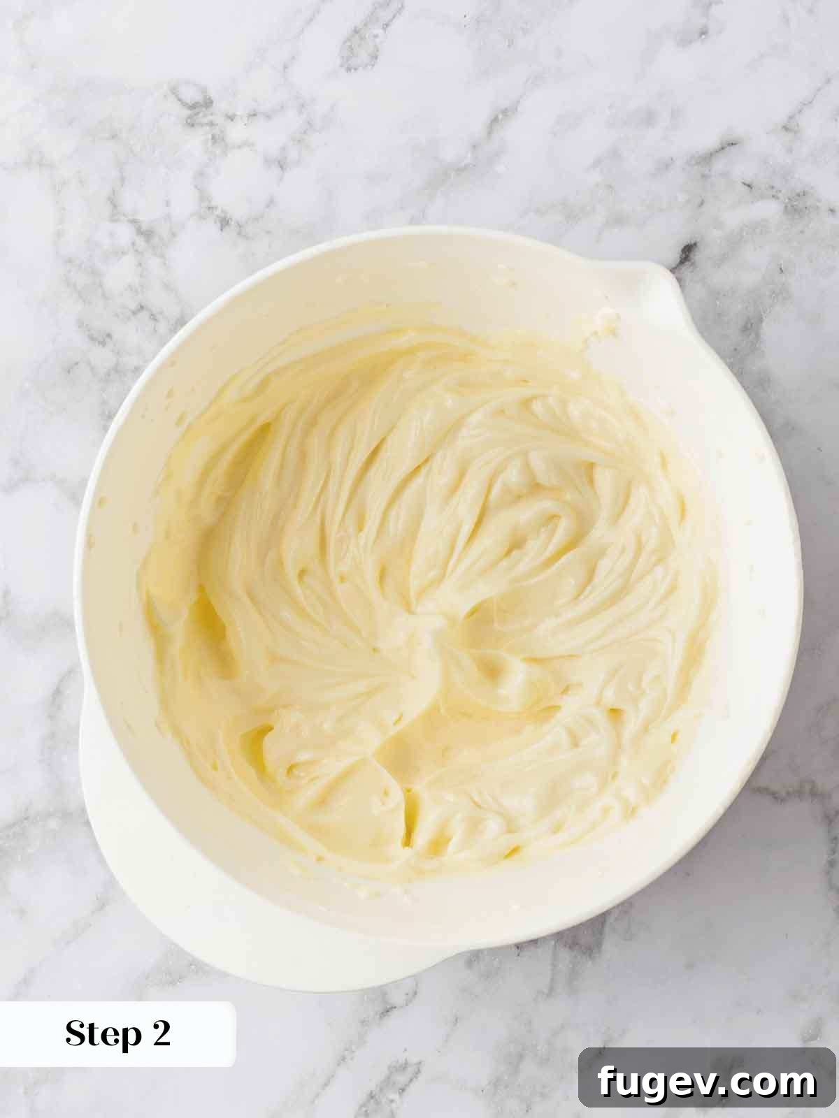 Luscious Banana Cake with Tangy Cream Cheese Frosting 9 A bowl of perfectly smooth, creamy cream cheese frosting, swirled and ready to be spread onto a cake or cupcakes.