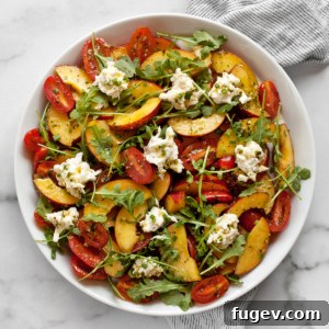 A vibrant peach tomato burrata salad, beautifully presented on a plate, ready to be served.
