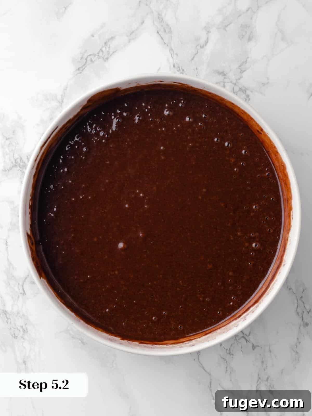 Decadent Chocolate Raspberry Indulgence 12 A mixing bowl filled with rich, dark chocolate cake batter, smooth and glossy, ready to be poured into the prepared pans.