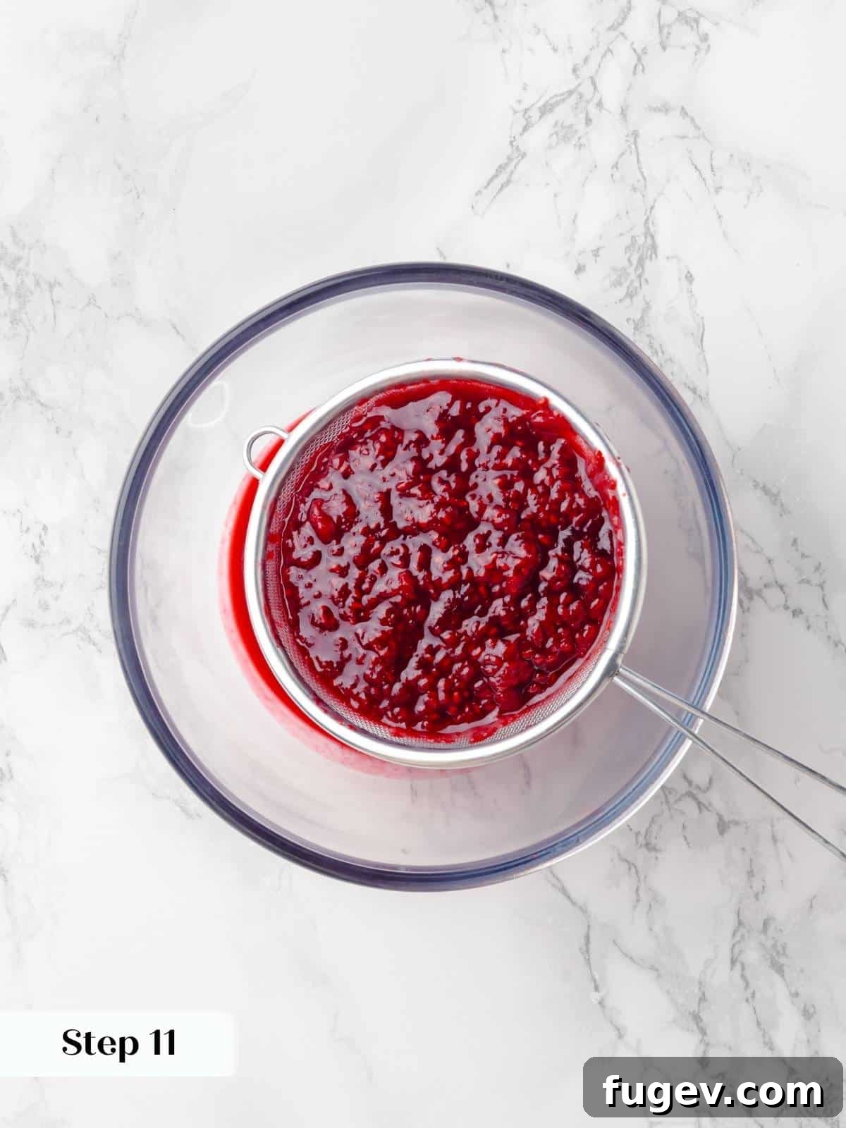 Decadent Chocolate Raspberry Indulgence 15 Fresh raspberries being strained through a fine-mesh sieve to remove seeds, ensuring a smooth jam for the cake.