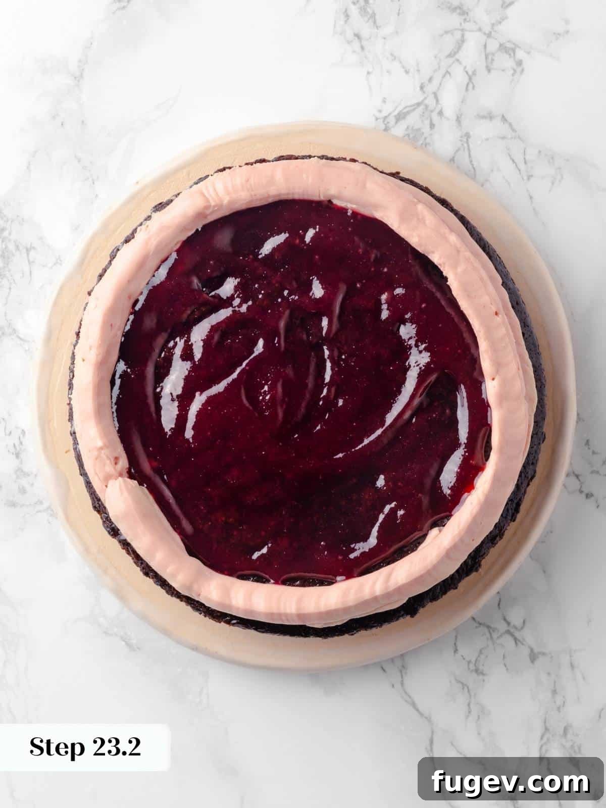Decadent Chocolate Raspberry Indulgence 24 The first cake layer generously topped with a bright layer of raspberry jam and a piping of raspberry buttercream around the edge.