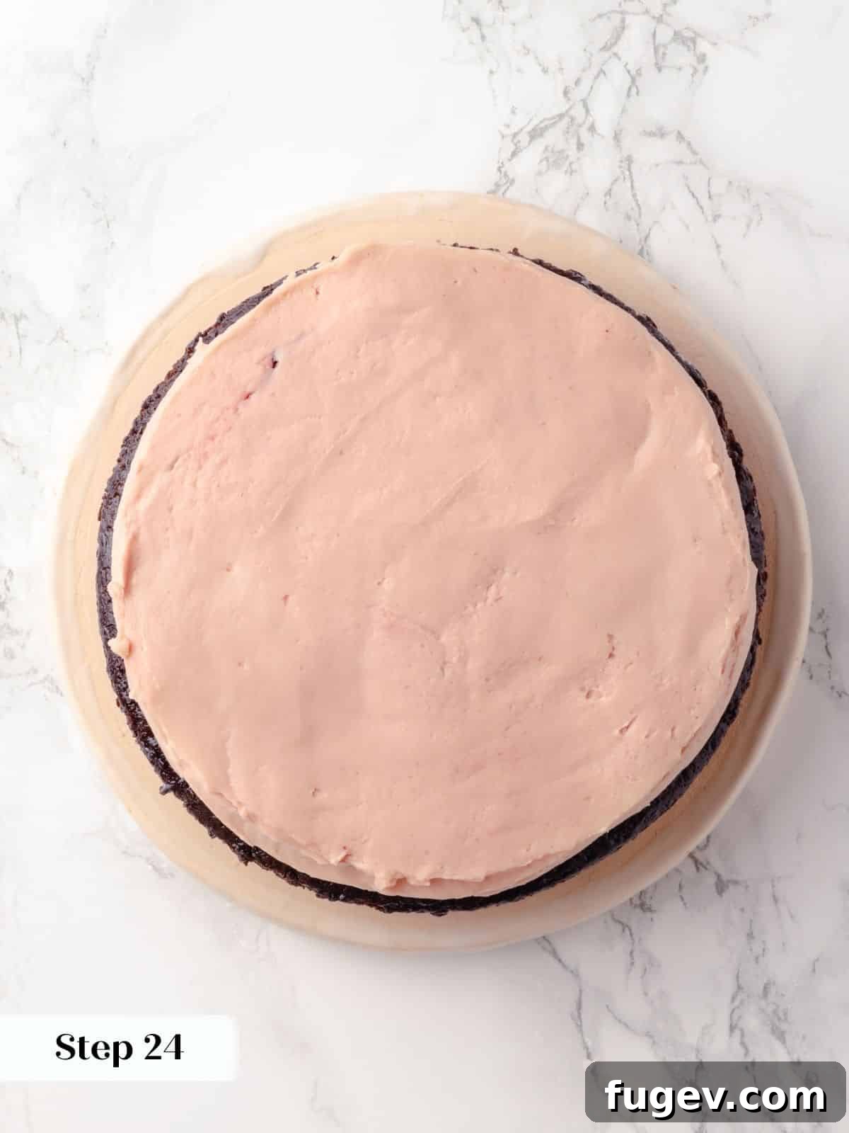 Decadent Chocolate Raspberry Indulgence 25 Raspberry buttercream carefully smoothed over a layer of raspberry jam on the chocolate cake, creating an even surface.