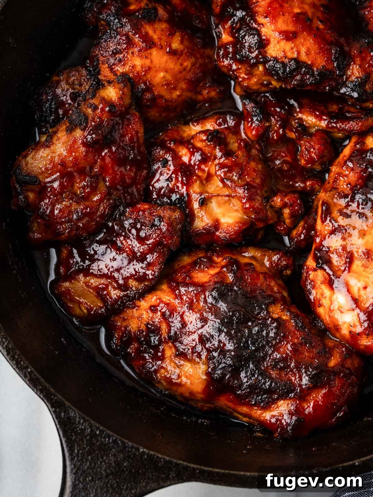 Tender Oven-Baked BBQ Chicken Breast 2 Perfectly baked bbq chicken in a cast iron skillet, glistening with maple chipotle sauce.