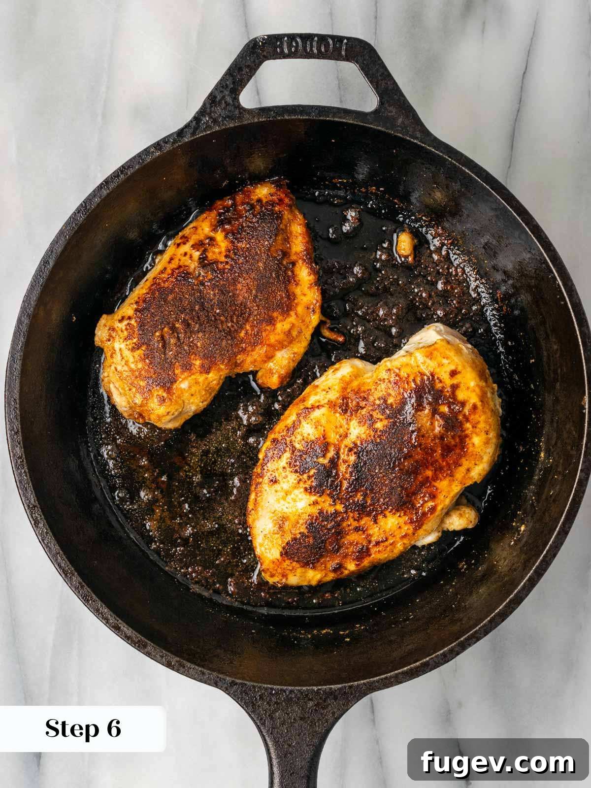 Tender Oven-Baked BBQ Chicken Breast 10 Boneless, skinless chicken breasts searing in a hot black cast iron skillet.