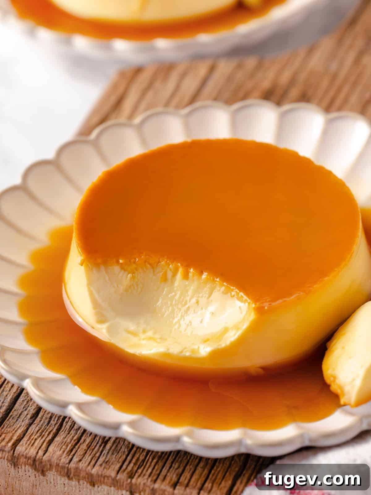 Silky Caramel Custard 2 A crème caramel dessert with a bite taken out, revealing its creamy, smooth texture and glistening caramel sauce.