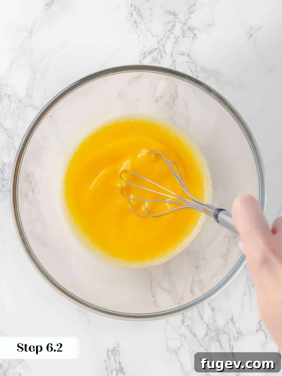Silky Caramel Custard 11 Eggs being whisked vigorously in a mixing bowl to create a light and airy custard base for creme caramel.