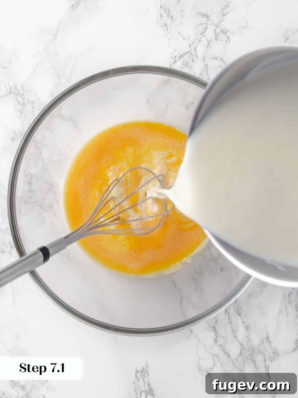 Silky Caramel Custard 12 Warm milk being slowly poured into whisked eggs, tempering them for the custard mixture, ensuring a smooth texture.