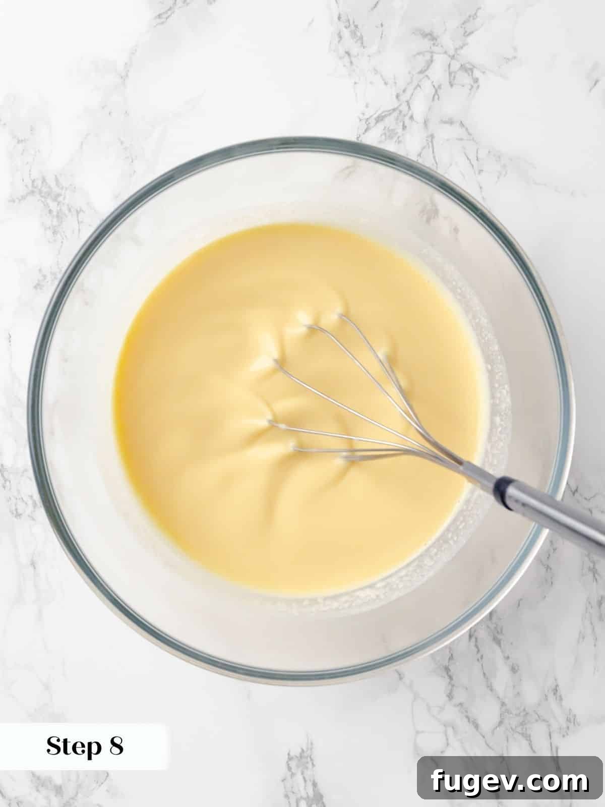Silky Caramel Custard 13 Vanilla extract being whisked into a creamy custard mixture, infusing it with flavor for creme caramel.