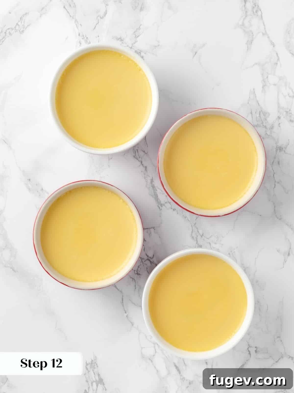 Silky Caramel Custard 15 Custard-filled ramekins baking in a water bath, covered with foil to ensure even cooking.
