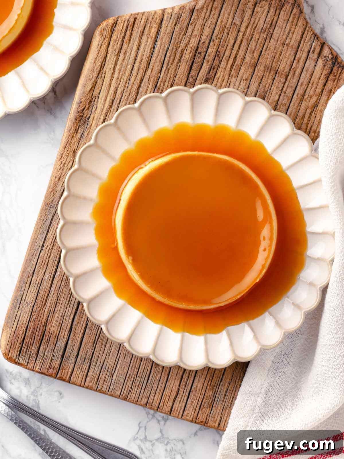 Silky Caramel Custard 16 A perfectly inverted crème caramel portion on a white plate, showcasing the rich caramel sauce flowing over the smooth custard.