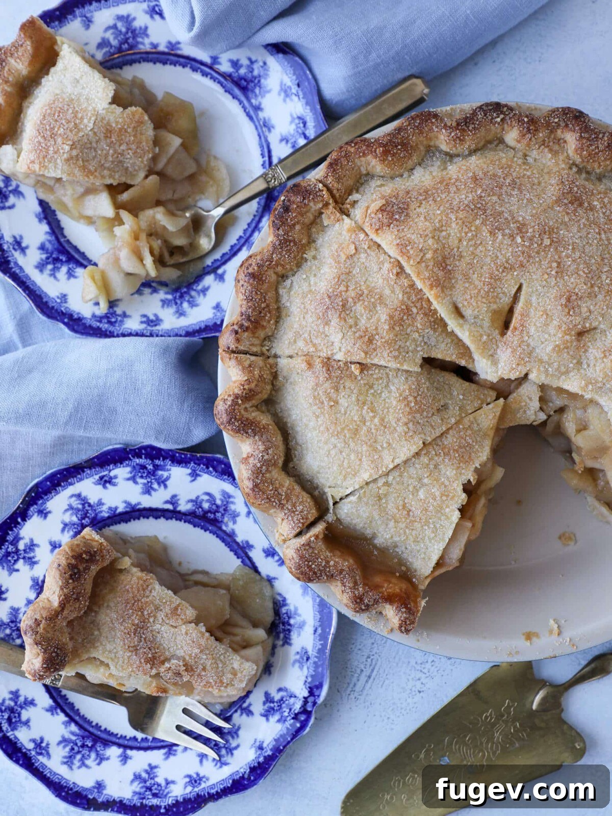 Epic Apple Pie 2 A beautifully baked Mile High Apple Pie, golden brown and inviting, set on a rustic tablescape ready to be served.