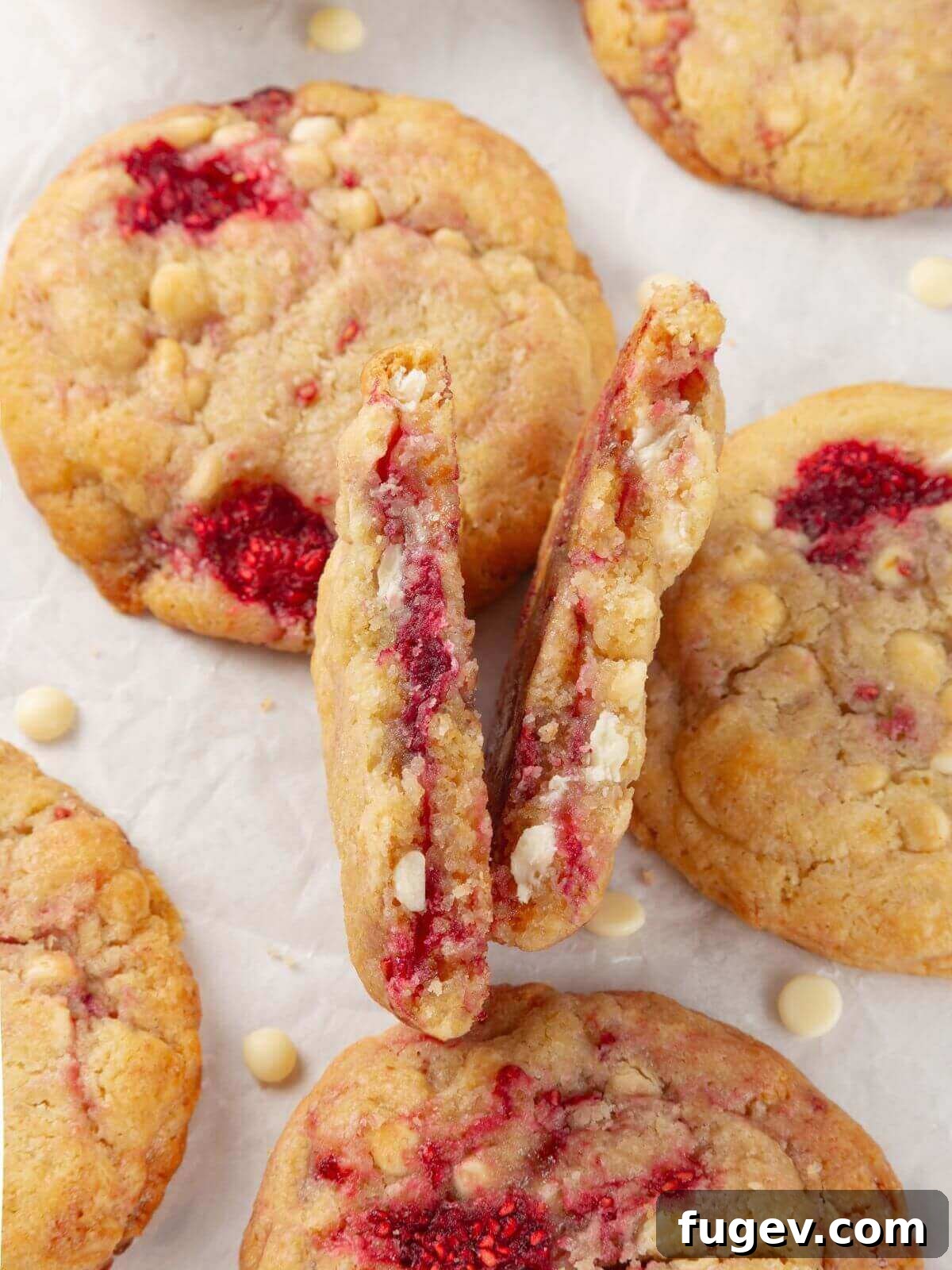 Velvet White Chocolate Raspberry Cookies 2 A close-up of a white chocolate raspberry cookie with a chewy, soft interior and melted chocolate, showcasing its irresistible texture.