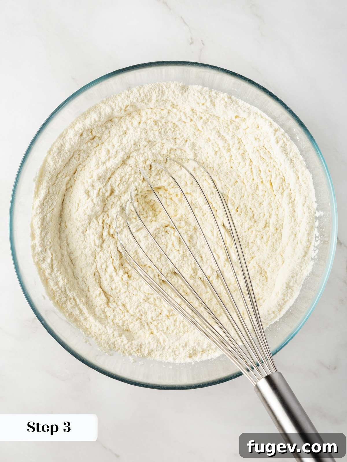 Velvet White Chocolate Raspberry Cookies 5 Dry ingredients being meticulously whisked together in a bowl to ensure even distribution and prevent clumps in the cookie dough.