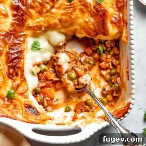 A rustic white baking dish filled with a comforting Chicken Shepherd’s Pie, ready for serving.