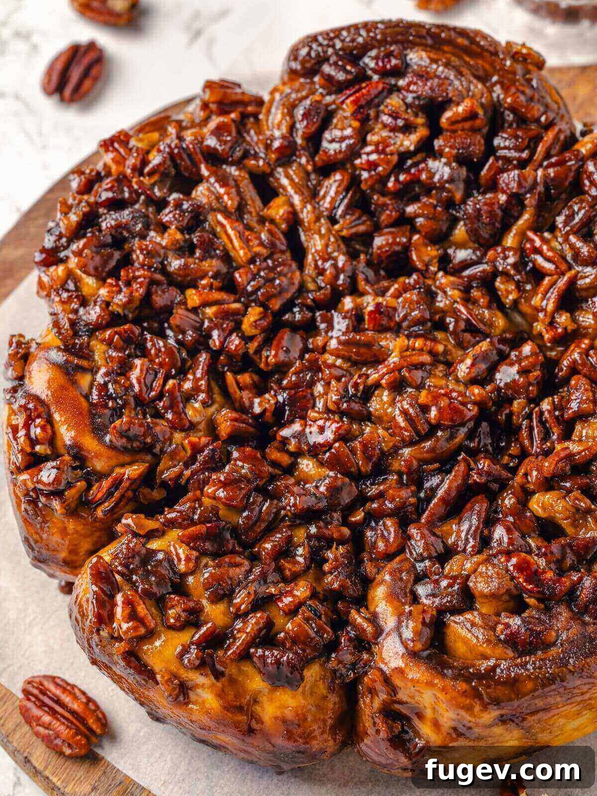 Gooey Pecan Caramel Rolls 2 Close-up of sticky buns with glossy, caramelized pecan topping.