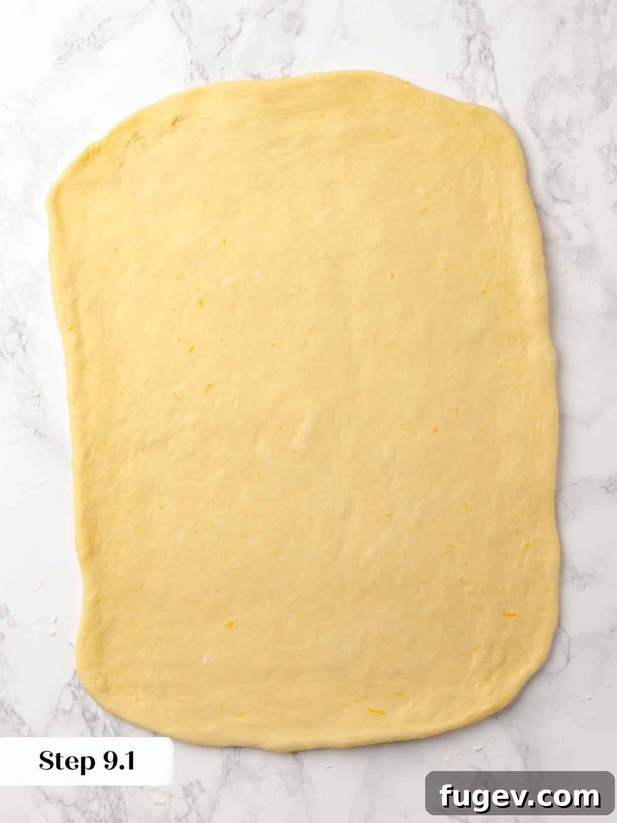 Gooey Pecan Caramel Rolls 16 Sticky bun dough rolled into a large rectangle on a floured surface.