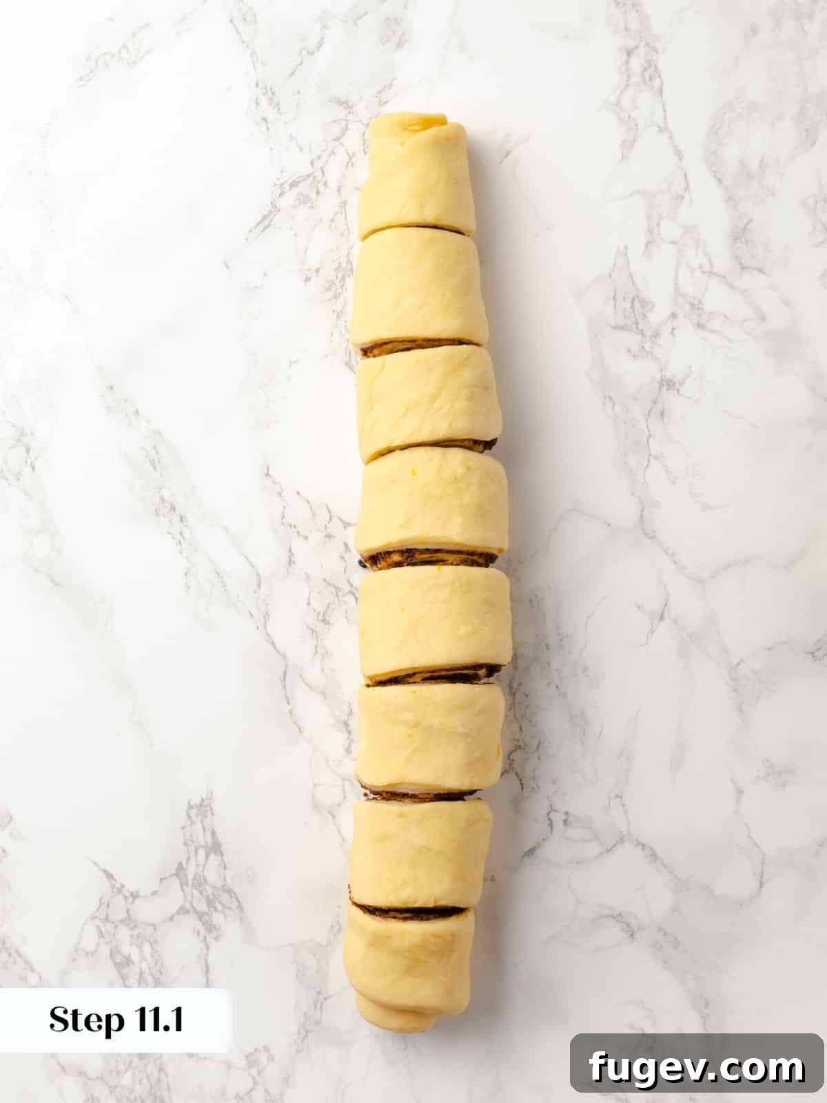 Gooey Pecan Caramel Rolls 20 A rolled log of sticky bun dough sliced into even pieces.