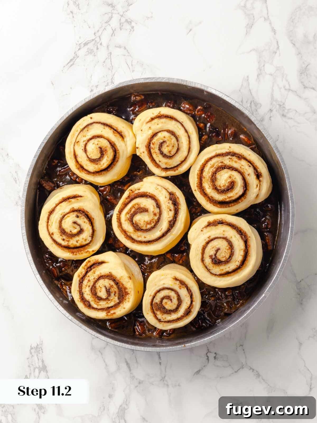 Gooey Pecan Caramel Rolls 21 Cinnamon-swirled dough pieces placed in a round pan for baking.