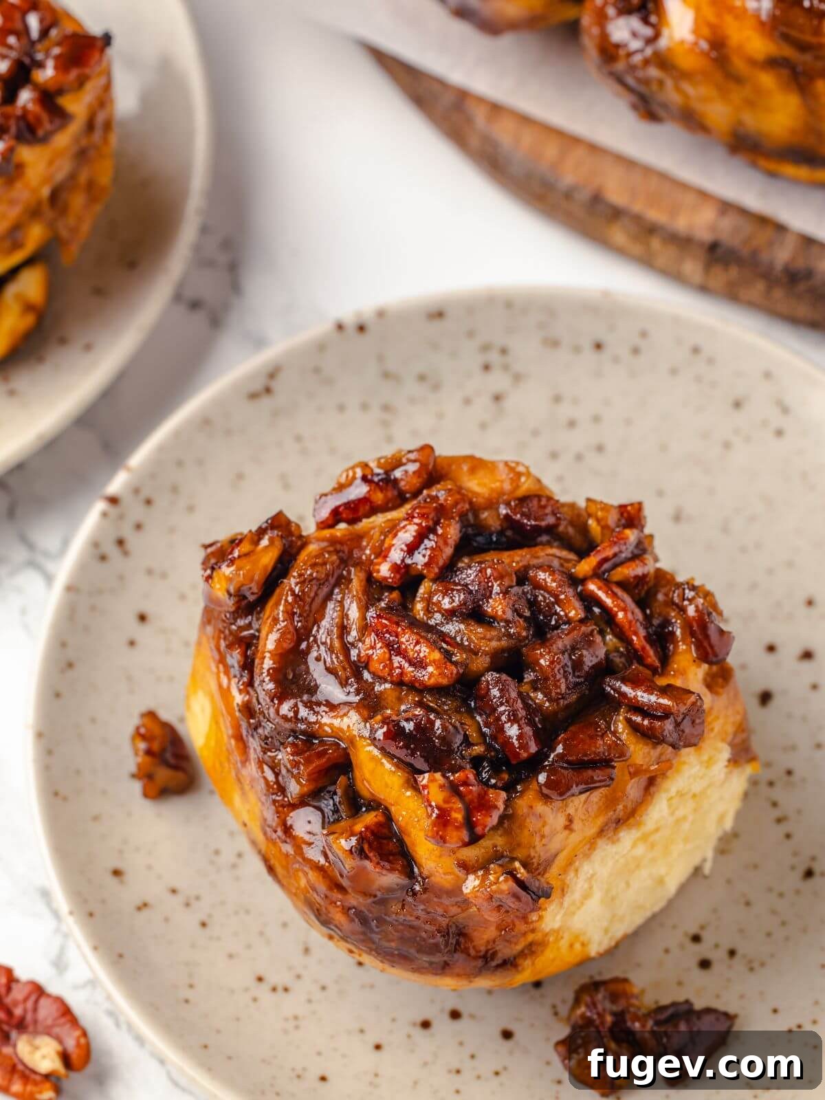 Gooey Pecan Caramel Rolls 26 Close-up of a single pecan sticky bun showing its gooey topping.
