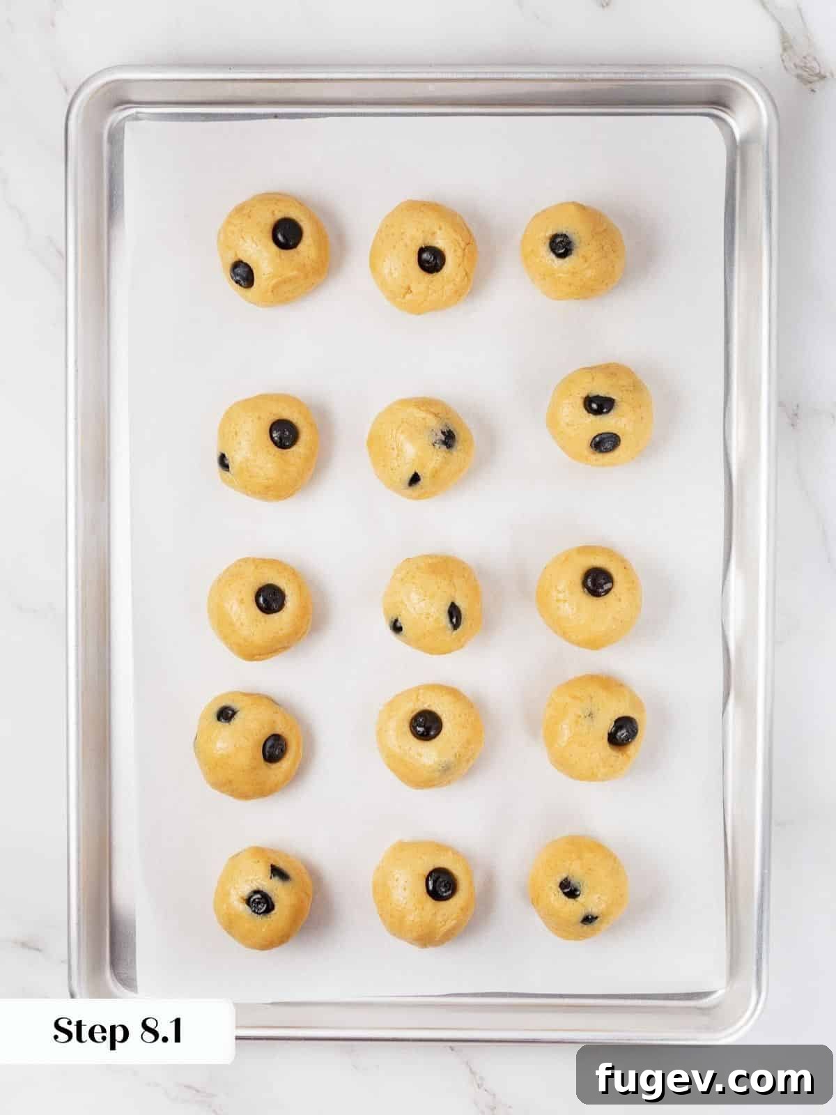 Bright Lemon Blueberry Delights 15 Neatly portioned cookie dough balls lined up on a parchment-lined baking sheet, ready for chilling.