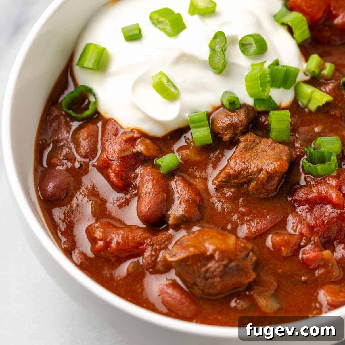 Hearty Steak Chili 3 Steak chili served in a white bowl with a spoon.