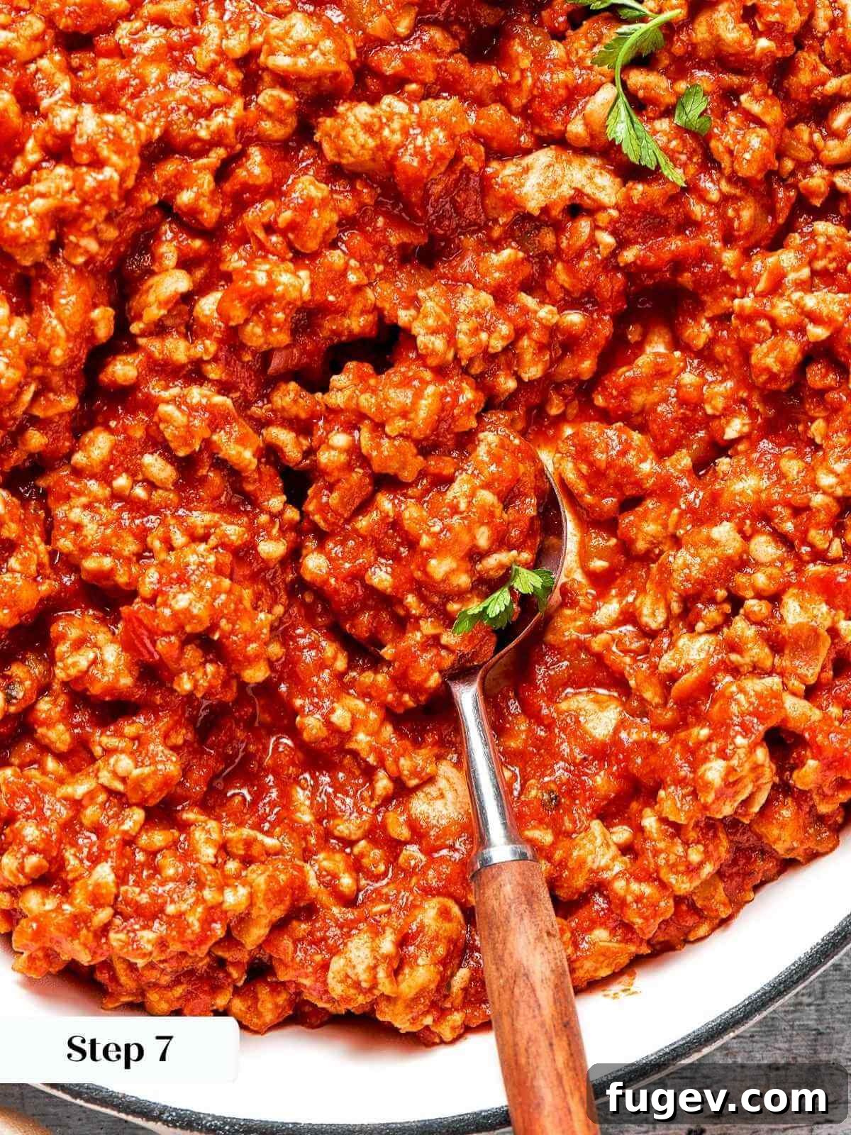 Homestyle Turkey Sloppy Joes 11 A spoon scooping a large portion of the saucy turkey sloppy joe mixture from the pan.