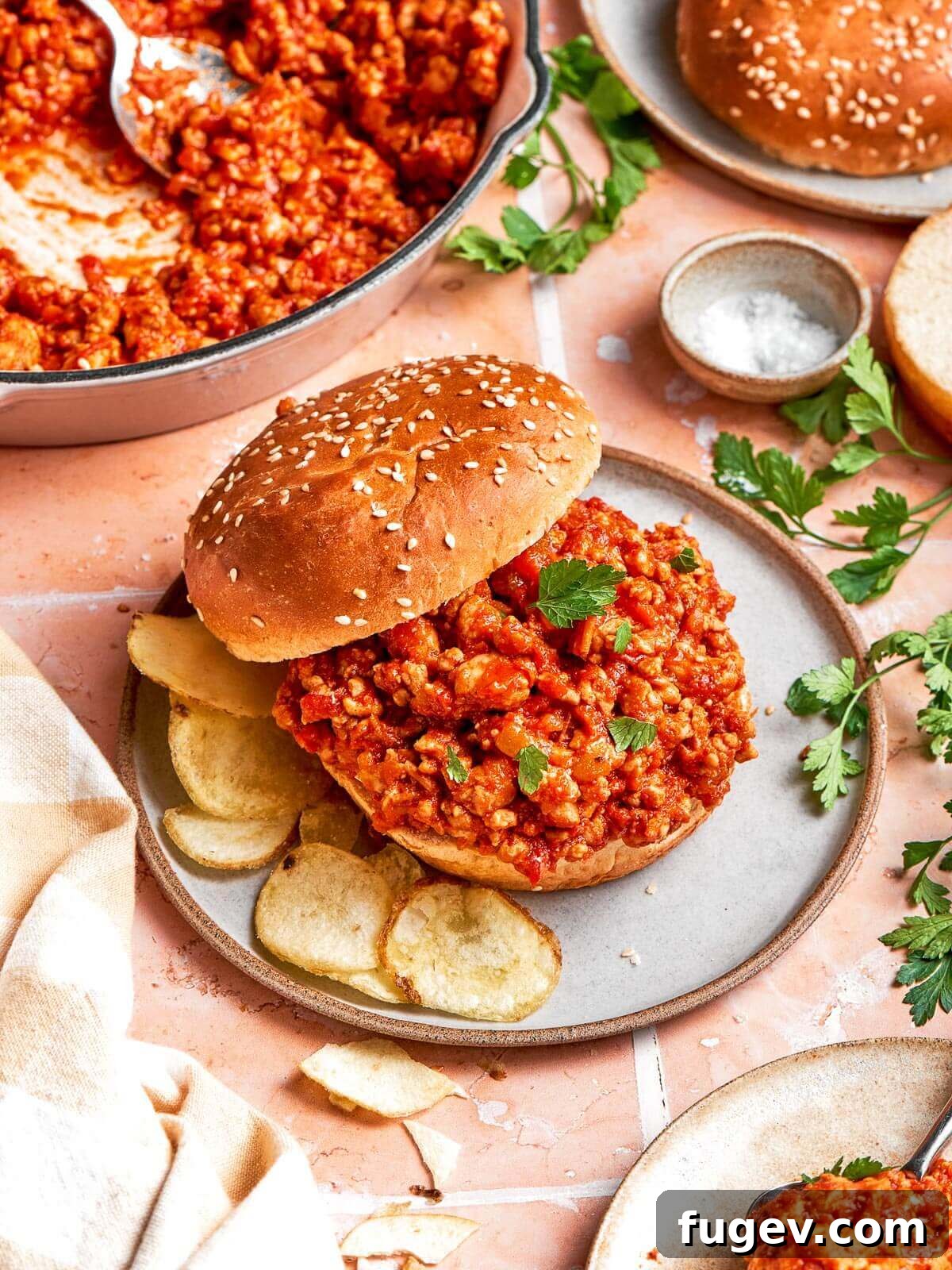 Homestyle Turkey Sloppy Joes 13 A complete plate of turkey sloppy joe sandwich served alongside a generous portion of crispy potato chips.