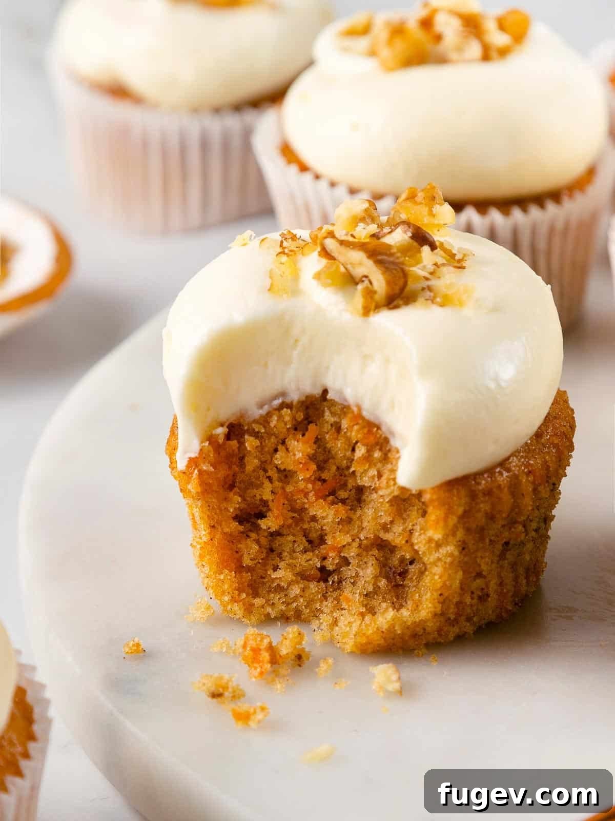 Decadent Carrot Cake Cupcakes 2 Beautifully frosted carrot cake cupcakes with a sprinkle of walnuts.