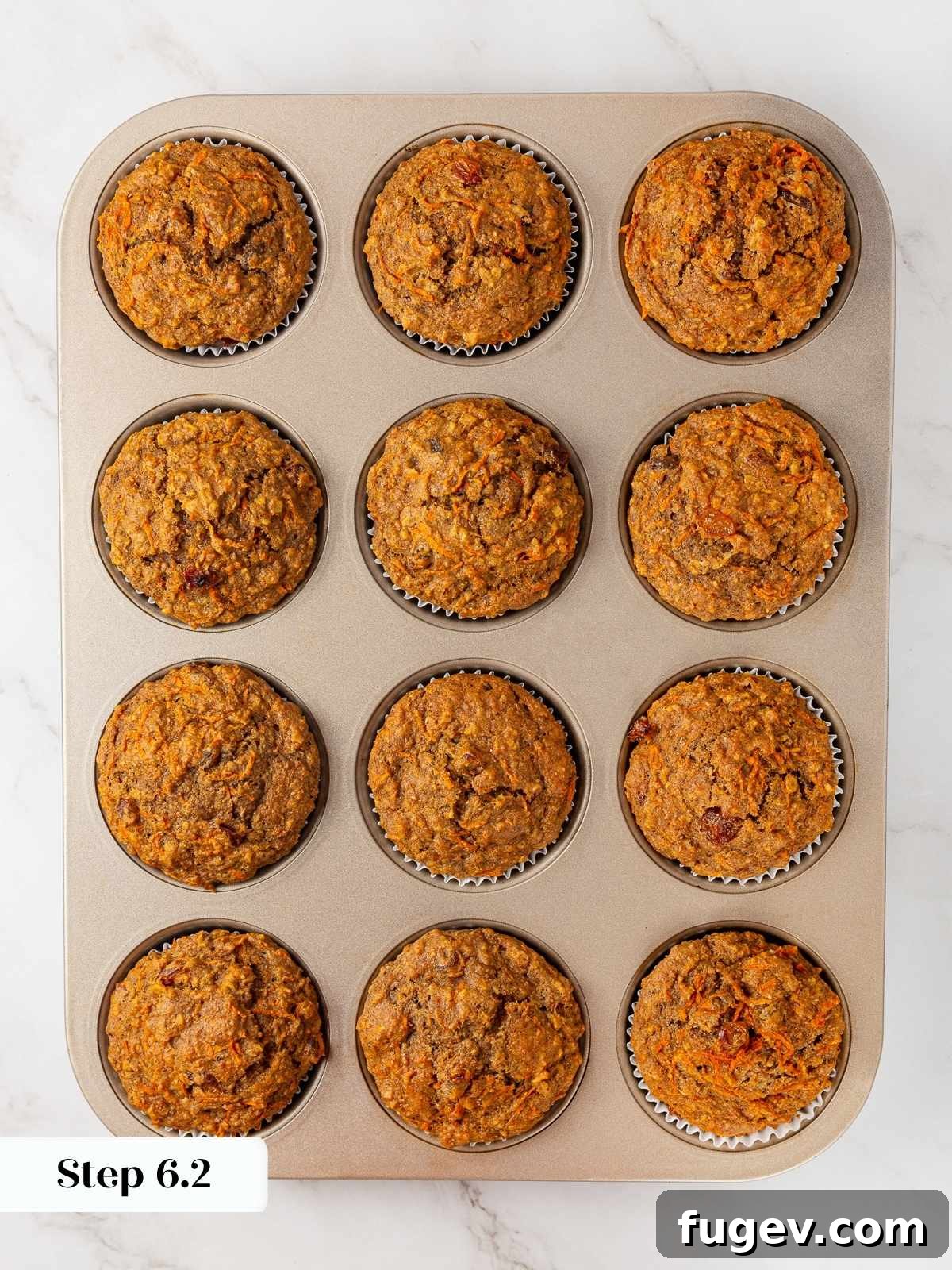 Wholesome Carrot Muffins 12 Freshly baked healthy carrot muffins in a muffin pan, just removed from the oven, with golden-brown tops.