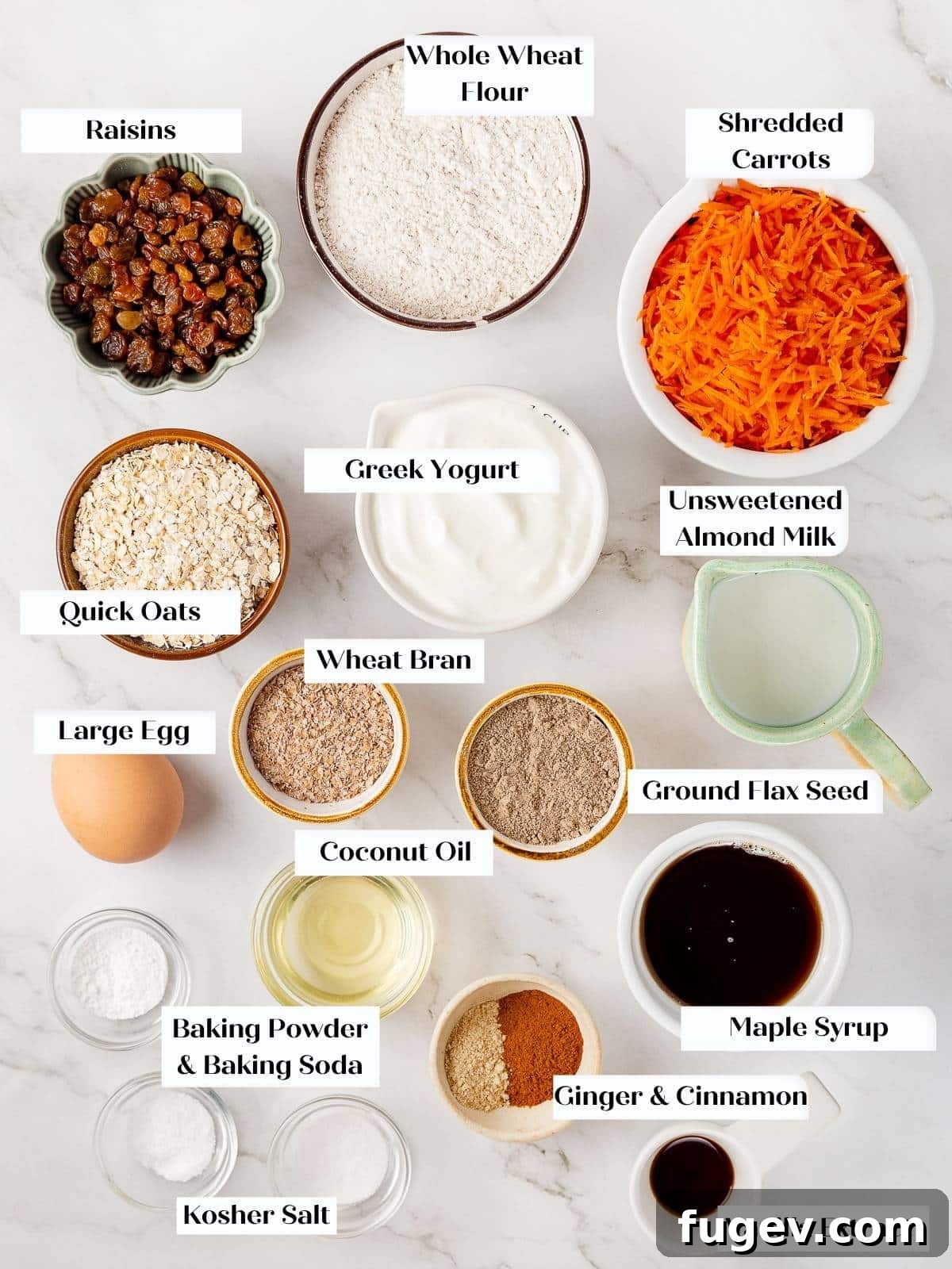 Wholesome Carrot Muffins 4 Various fresh ingredients for healthy carrot muffins, including flour, oats, spices, carrots, and liquids, neatly arranged on a kitchen counter.