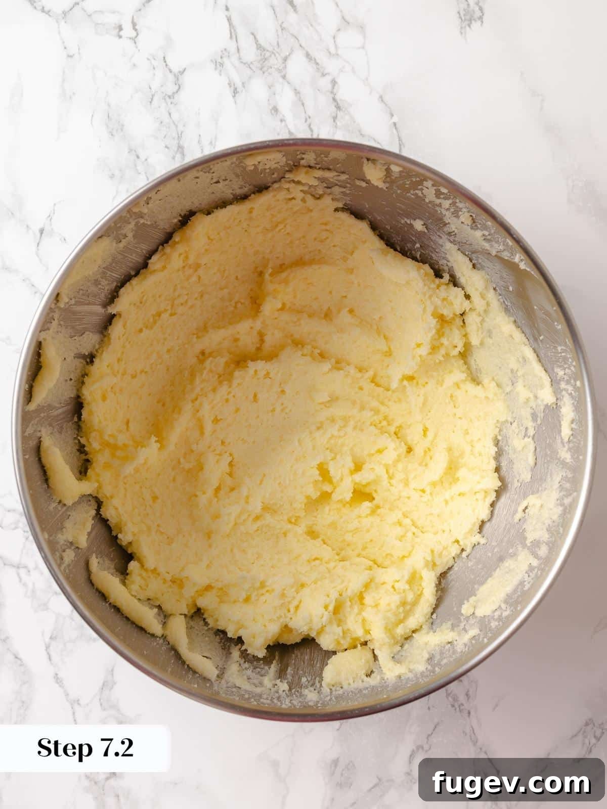 Strawberry Bliss Pound Cake 12 Creamed butter and sugar in a mixing bowl, transformed into a thick, pale, and airy paste, indicating proper aeration for the pound cake.
