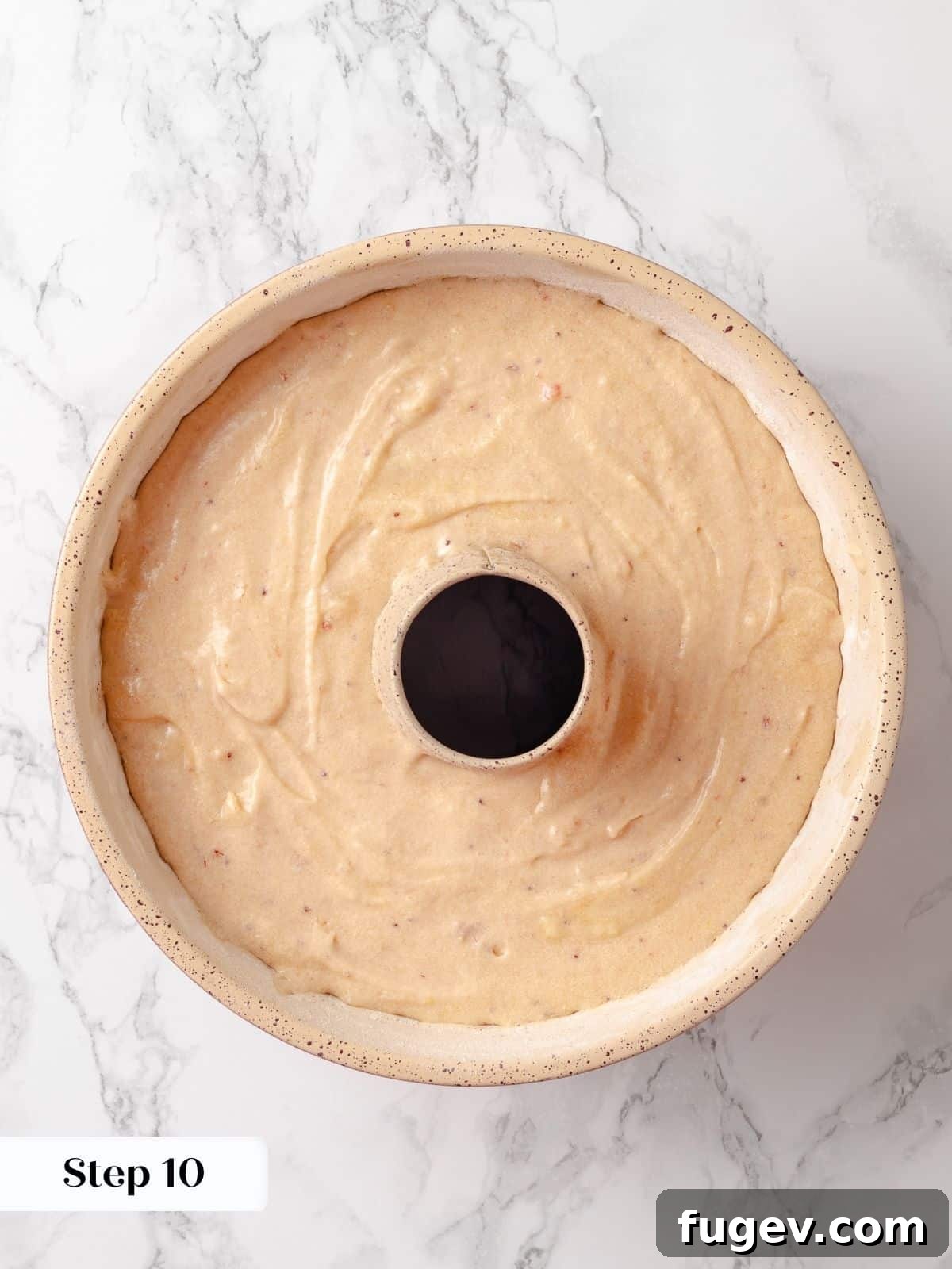 Strawberry Bliss Pound Cake 16 Smooth, light pink strawberry pound cake batter evenly spread into a meticulously prepared bundt pan, ready for baking to golden perfection.