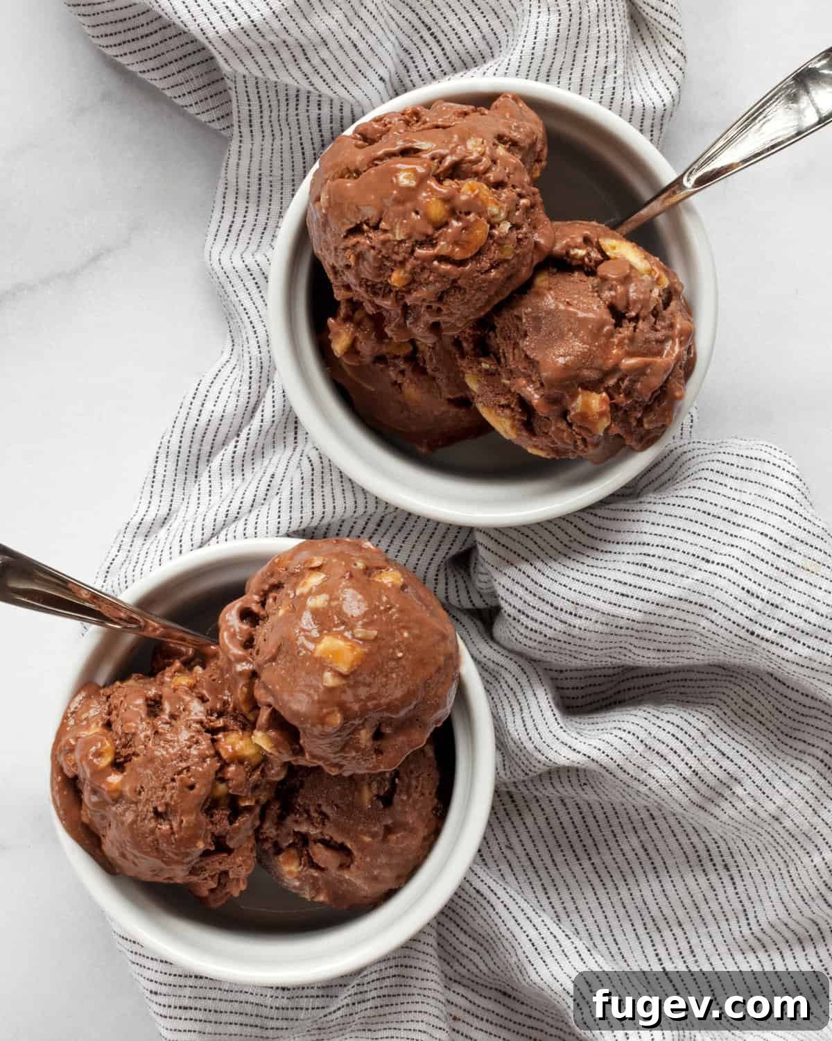 Salted Peanut Chocolate Ice Cream Bliss 2 Two bowls of chocolate nice cream garnished with peanuts and chocolate drizzle.