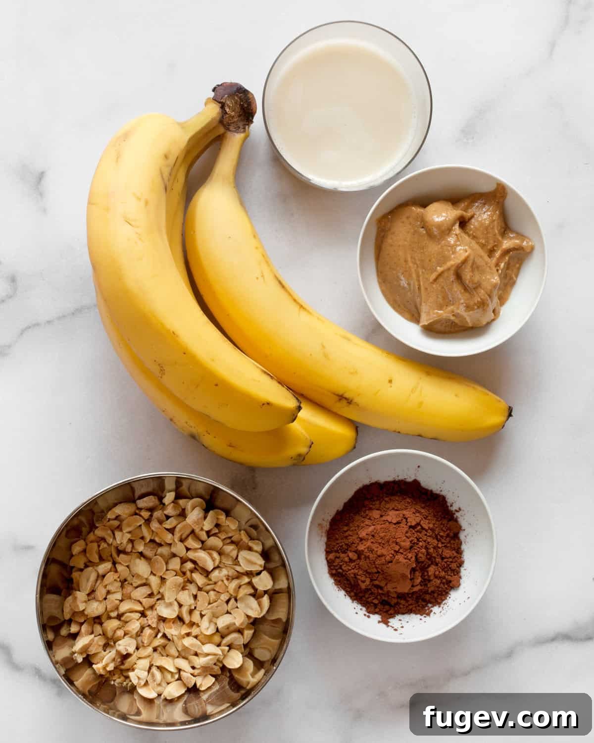 Salted Peanut Chocolate Ice Cream Bliss 4 Ingredients for chocolate nice cream laid out: bananas, plant milk, peanut butter, cocoa powder, and chopped peanuts.
