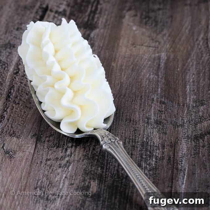 A spoonful of beautifully piped white buttercream, showcasing its smooth, airy texture.