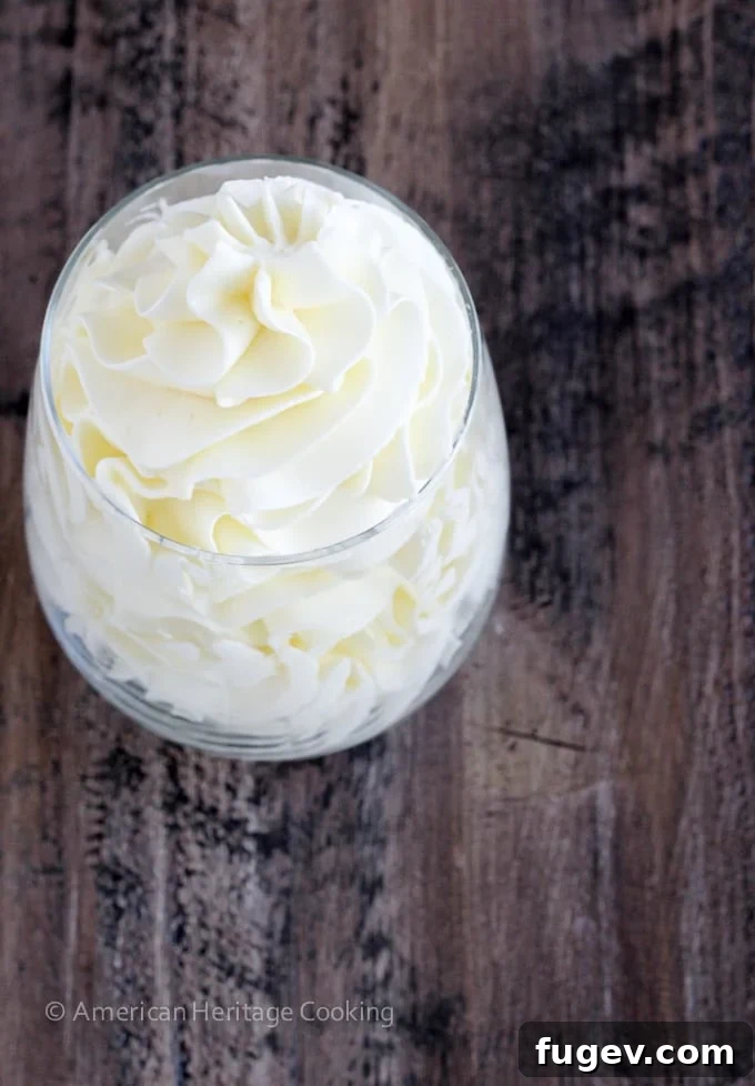 Gracefully swirled Italian meringue buttercream presented in a clear glass, showcasing its elegant texture.