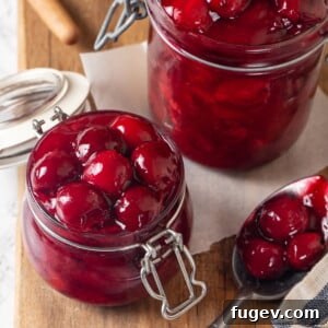 Syrupy cherry filling in a jar showing glossy, smooth texture and dark red color, indicating perfect consistency.