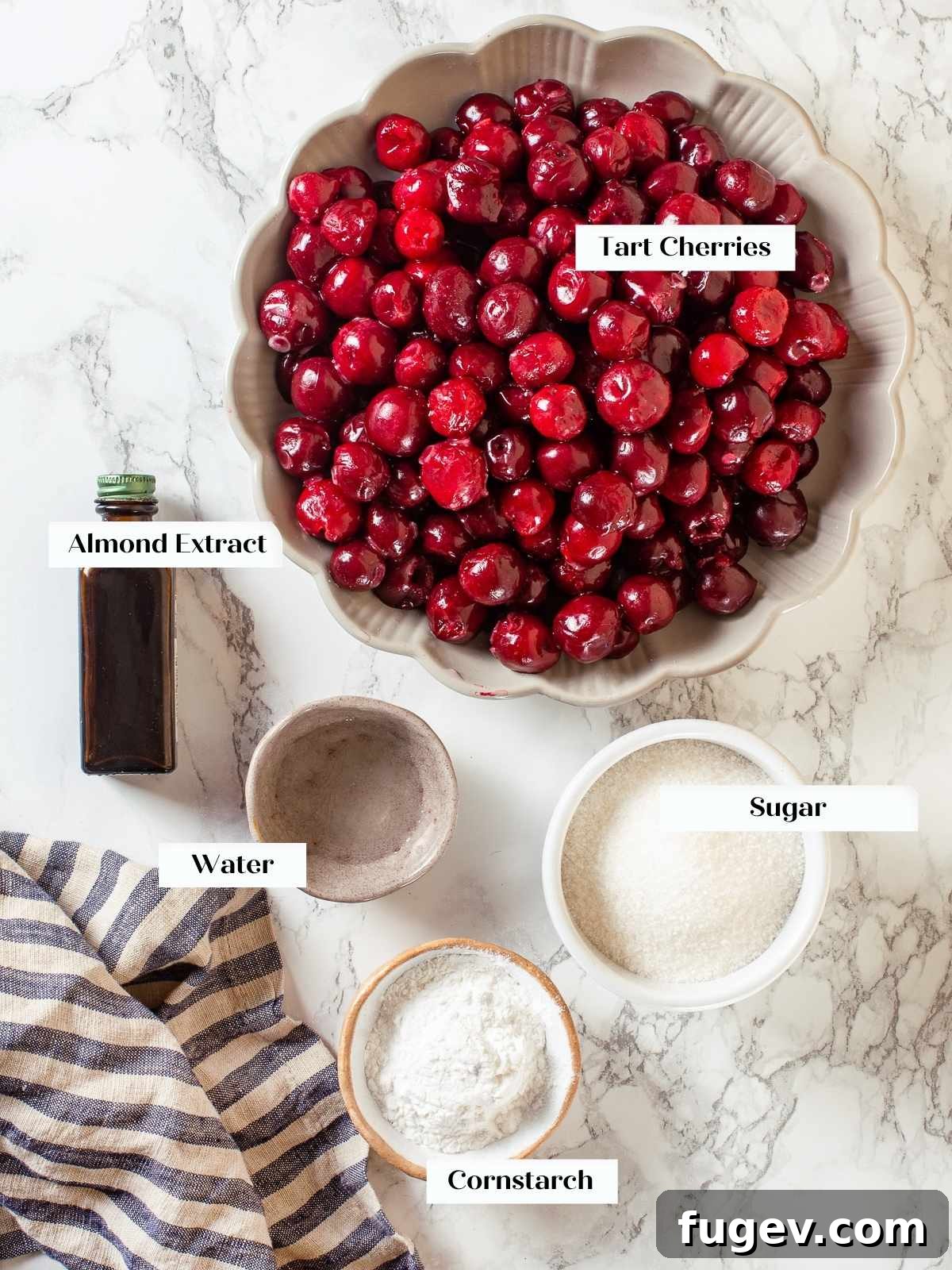 Homemade Cherry Pie Filling Perfection 4 Key ingredients for cherry pie filling laid out on counter, including fresh cherries, sugar, and almond extract, ready for preparation.