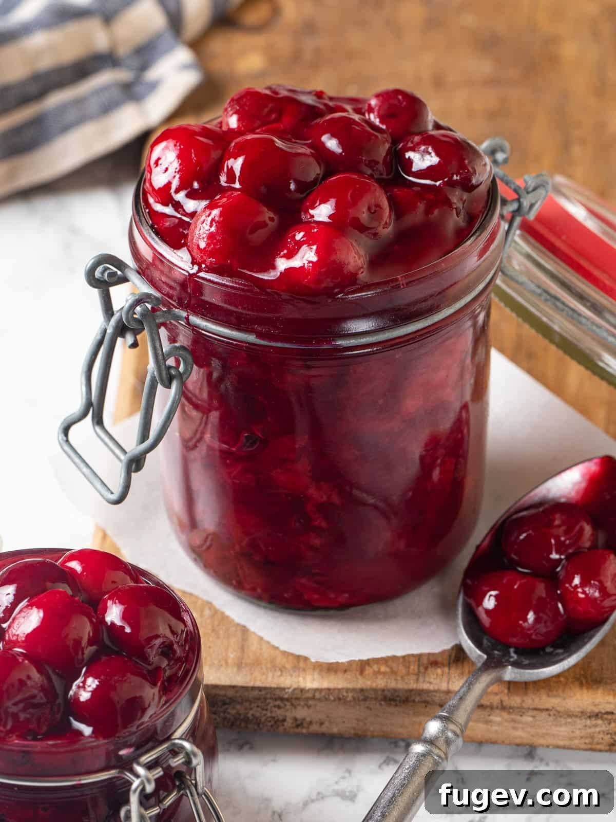 Homemade Cherry Pie Filling Perfection 8 Jar filled to the top with vibrant cherry pie filling, with syrup bubbling around the plump cherries, ready for storage.