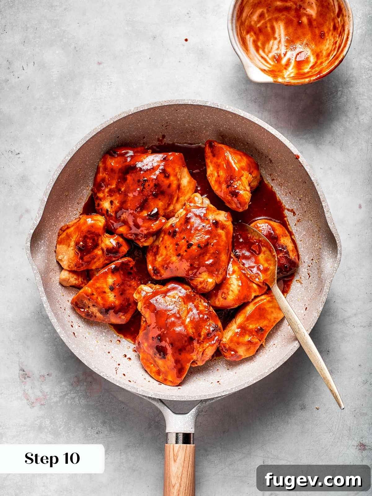 Gochujang Glazed Chicken 11 Chicken coated in thick red gochujang sauce after simmering in a pan.