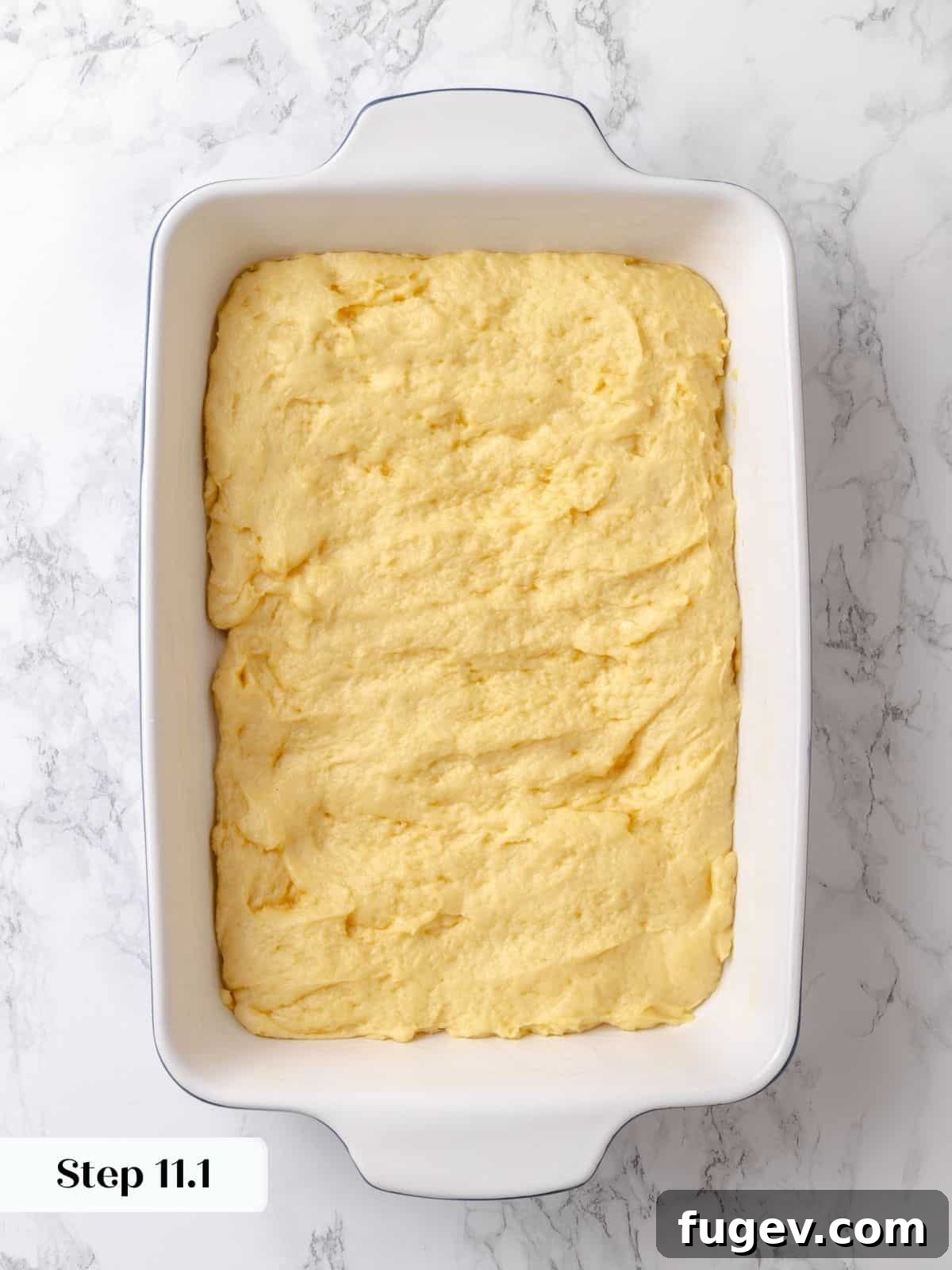 Melted Butter Dream 19 The cake dough has successfully risen in the pan, showing a gentle puff and a readiness to receive its signature sugar topping.