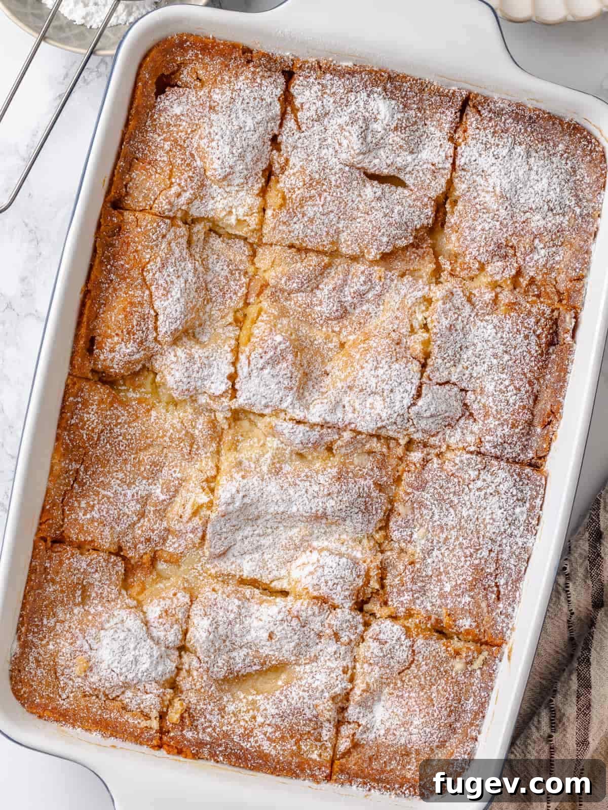Melted Butter Dream 25 Gooey butter cake expertly sliced into perfect squares, showcasing its irresistible gooey topping and soft, buttery crumb.