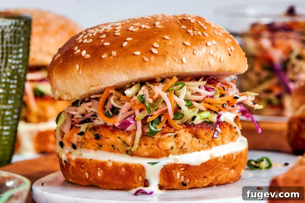 Gourmet Salmon Burgers 5 Fully assembled salmon burgers with slaw and sauce lined up and ready to eat.