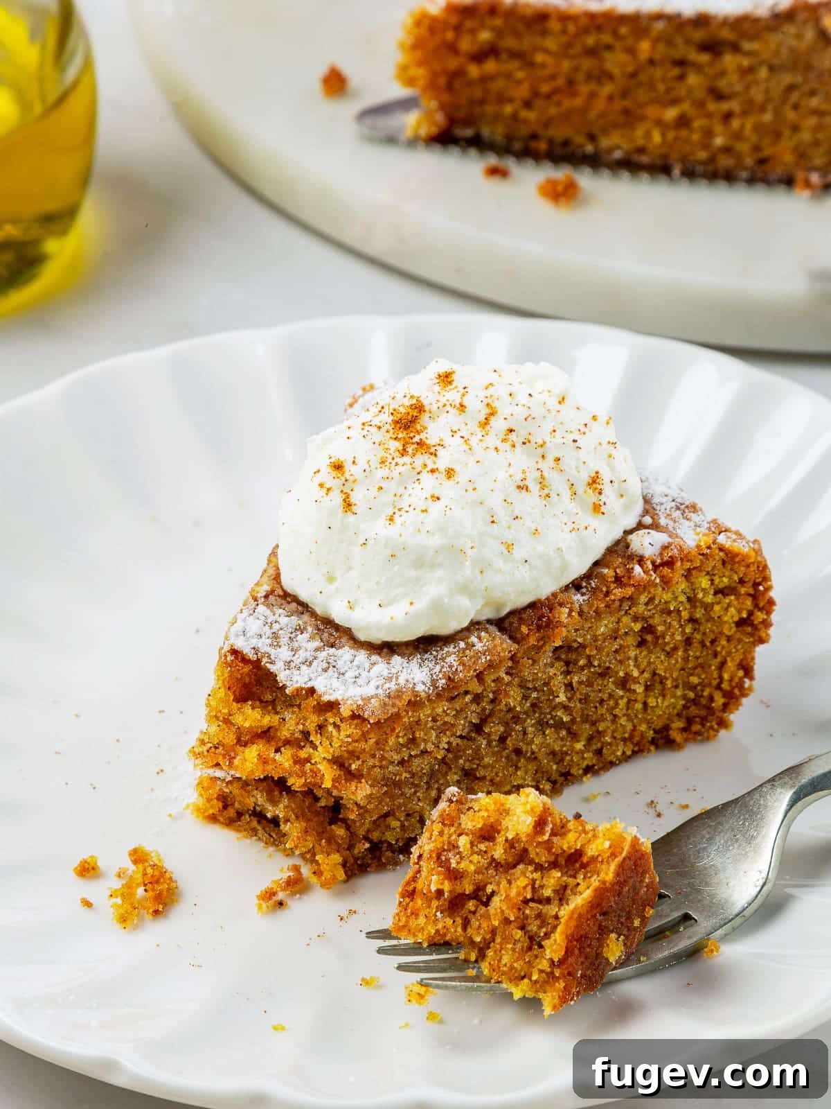 Velvety Pumpkin Olive Oil Cake 2 A delectable slice of pumpkin cake with a bite taken, revealing its incredibly soft, tender, and perfectly spiced center. Ideal for fall dessert recipes.