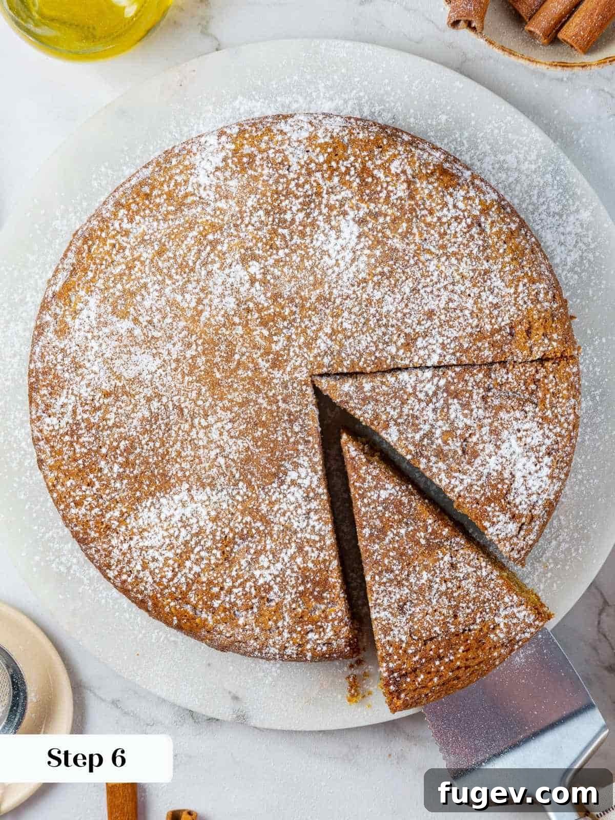Velvety Pumpkin Olive Oil Cake 11 A fine, even layer of powdered sugar elegantly coats the surface of the golden pumpkin cake after sifting, adding a simple yet beautiful final visual touch and a hint of sweetness.