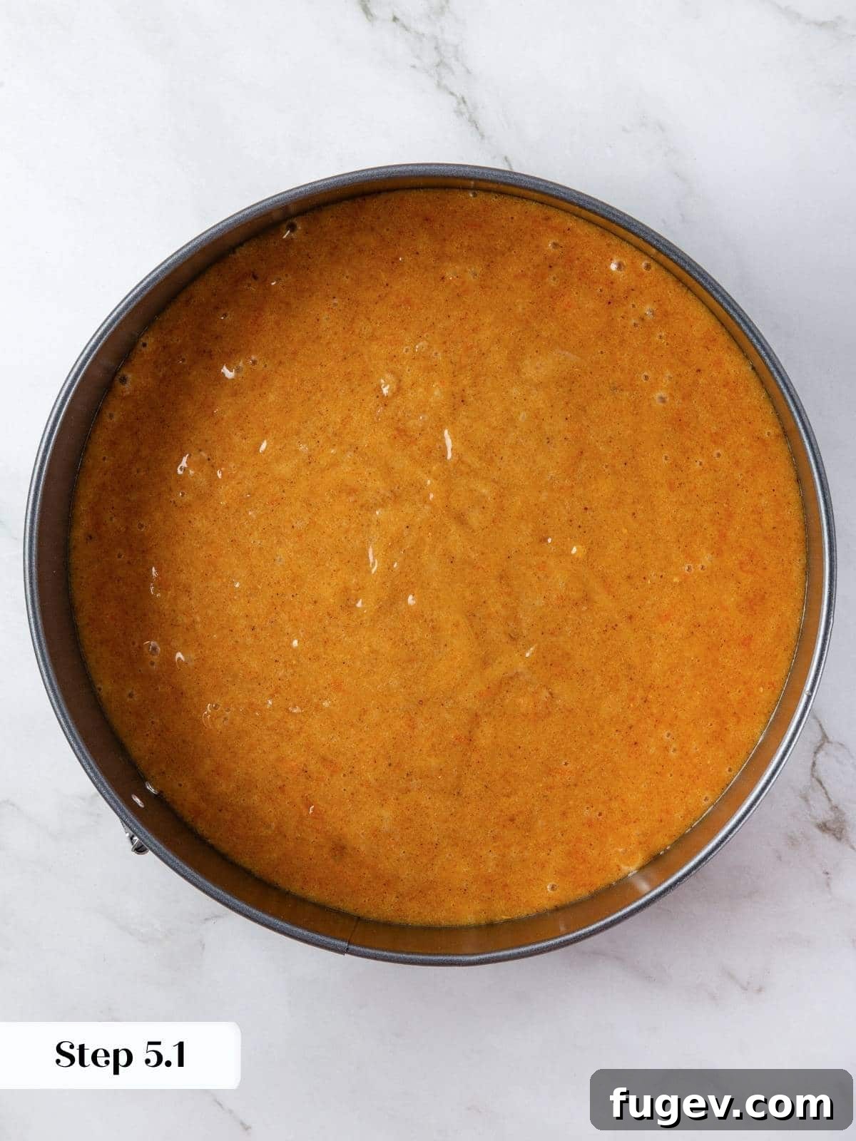Velvety Pumpkin Olive Oil Cake 9 A 9-inch round cake pan, expertly filled with the golden-orange pumpkin batter, smoothed evenly across the top using an offset spatula, ready for baking.