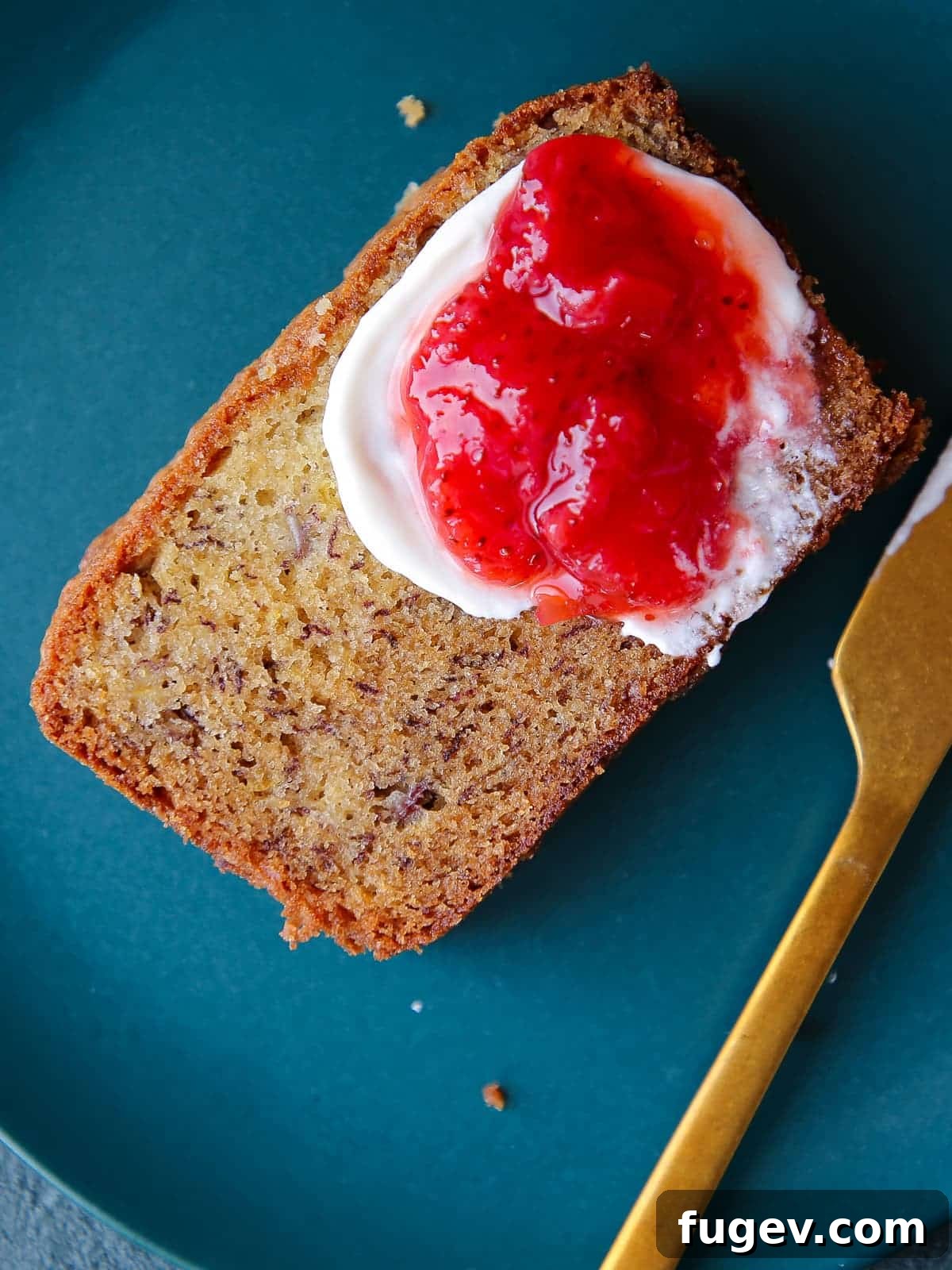 The Ultimate Moist Banana Bread 2 Thick slice of moist banana bread served on a vibrant blue ceramic plate, showcasing its soft texture and golden crust.