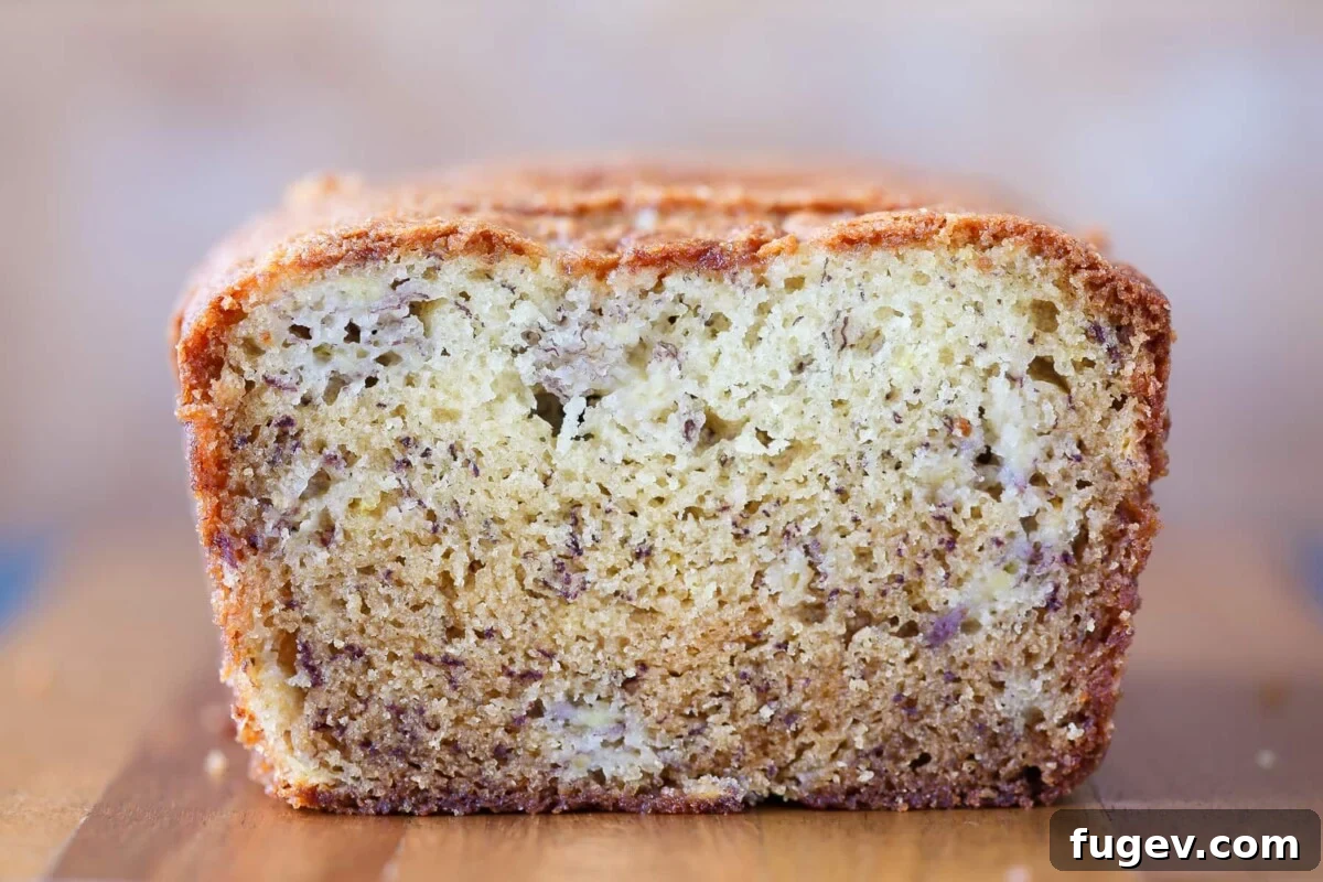The Ultimate Moist Banana Bread 3 Close-up shot of the soft, moist crumb texture inside a slice of banana bread, revealing its golden outer crust.