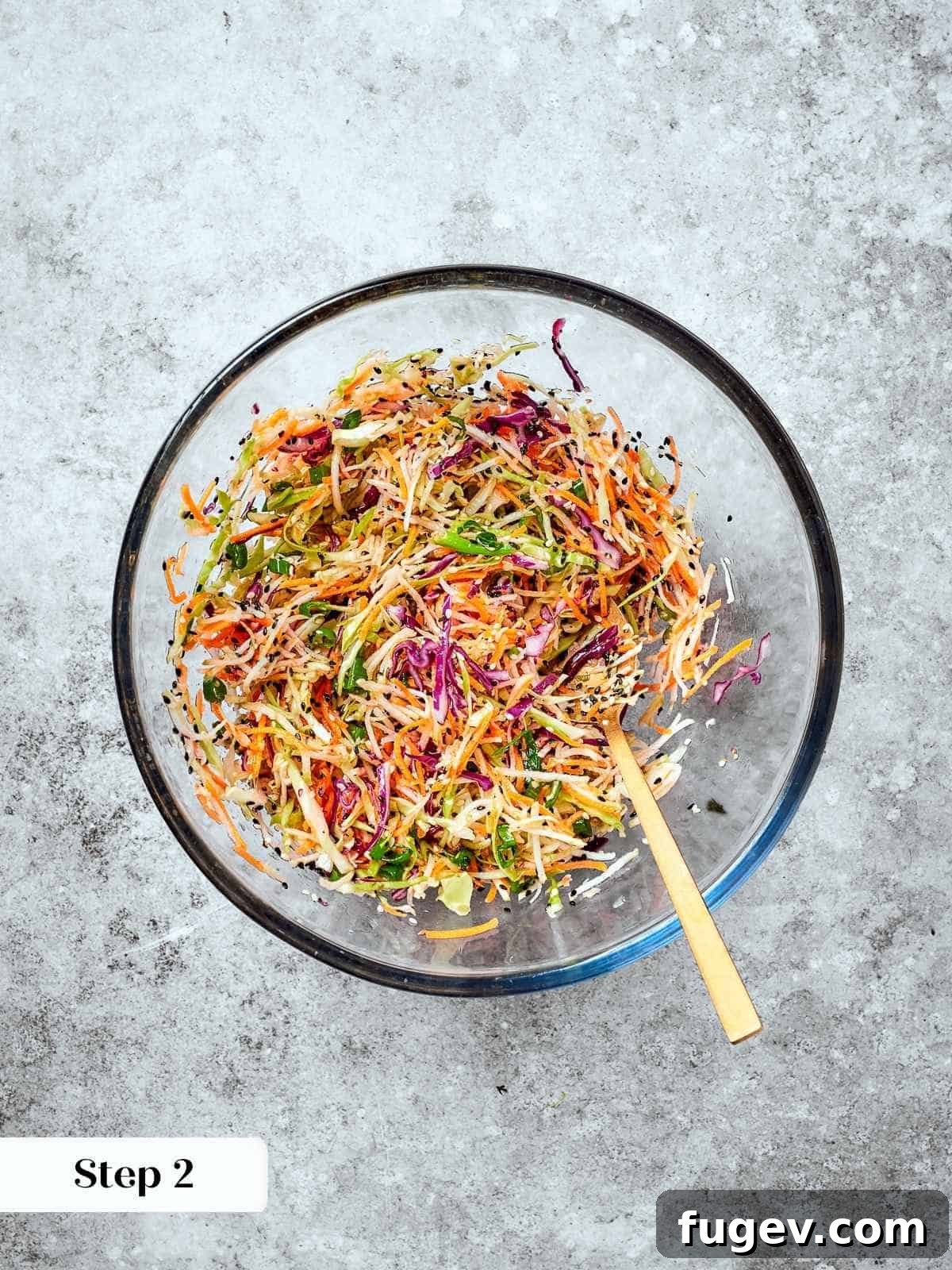 Wholesome Crunchy Broccoli Slaw 6 Broccoli slaw fully combined with dressing in a bowl, sesame seeds and carrots evenly coated.