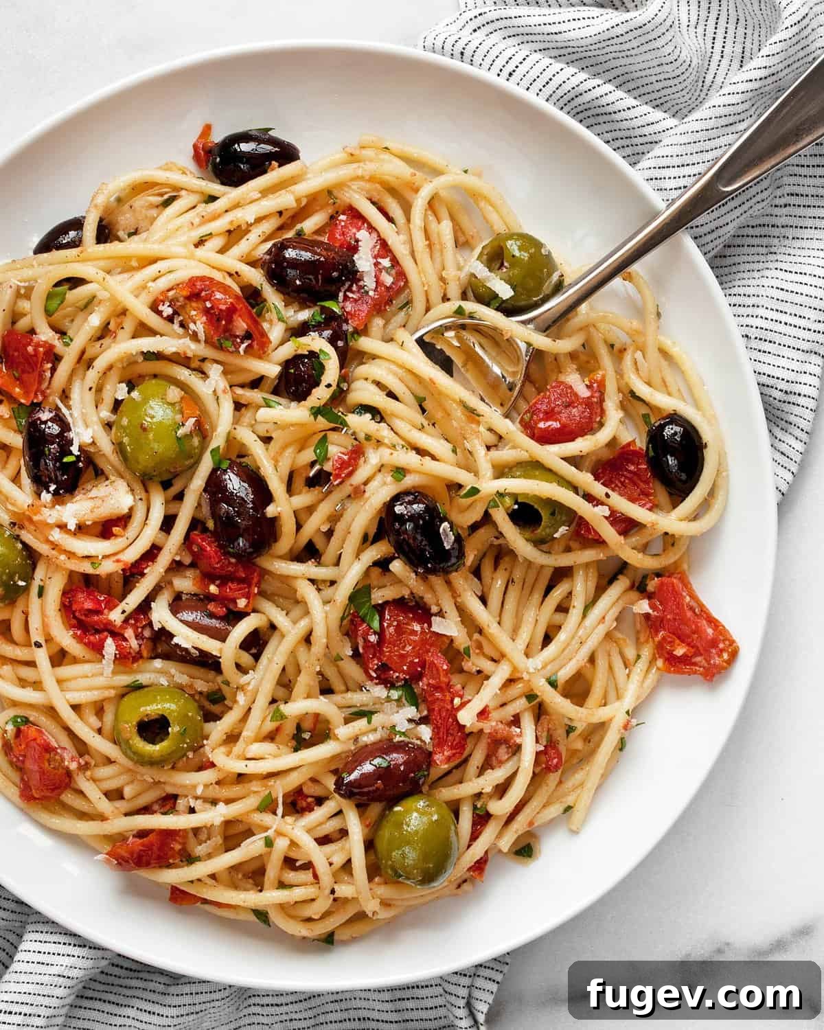 Antipasto Platter Pasta 3 Antipasto pasta served on a white plate with a fork, garnished with fresh herbs.